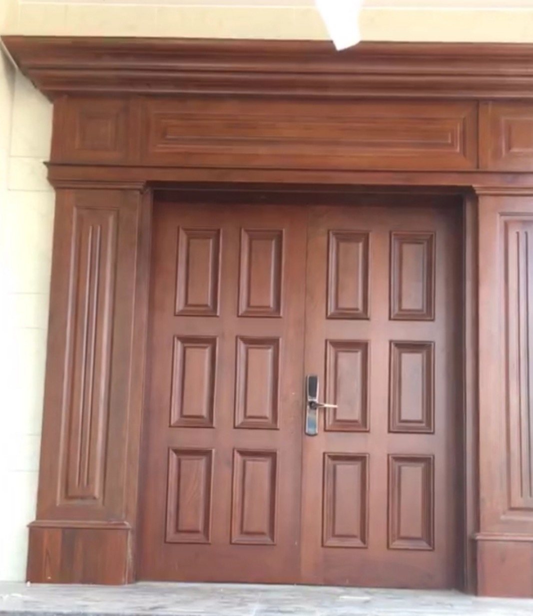 Finished teak front door installed at a home entrance