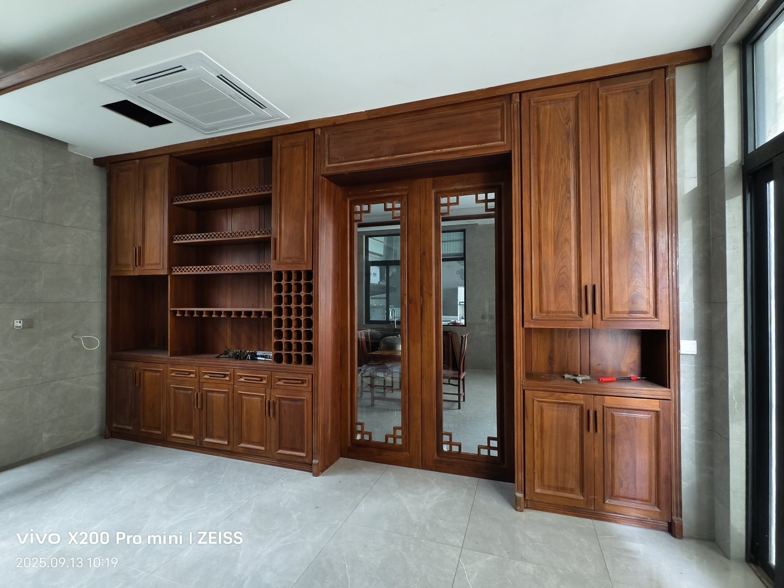 Custom teak paneling fitted around a window and ceiling line