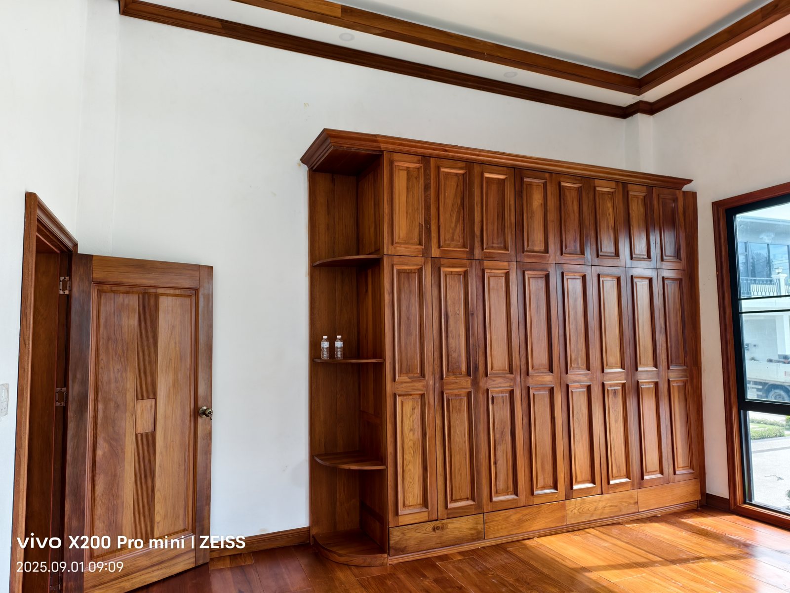 Solid teak walk-in closet with island and glass-front cabinets